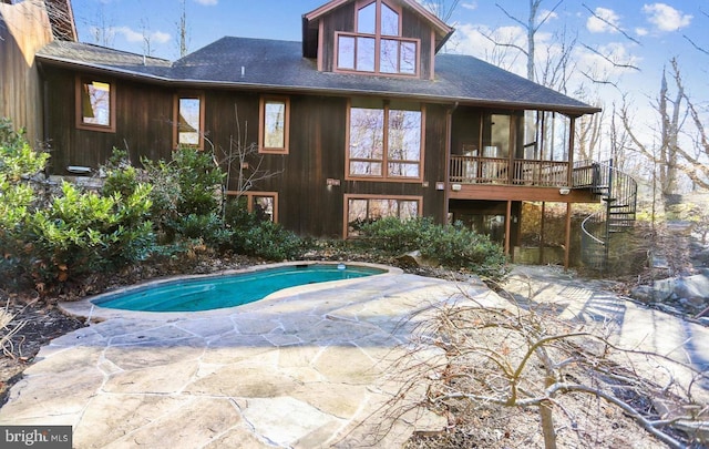 rear view of property featuring a patio area, an outdoor pool, a deck, and stairs