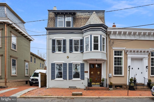 second empire-style home with crawl space, mansard roof, and brick siding