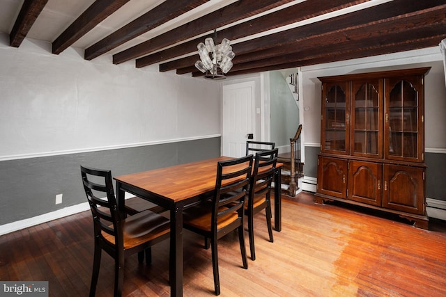 dining space with beam ceiling, light wood-style flooring, stairway, an inviting chandelier, and a baseboard radiator