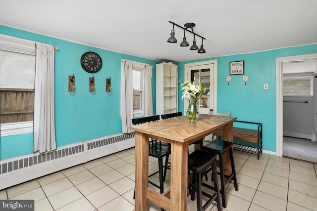 dining area with baseboards, baseboard heating, and light tile patterned flooring