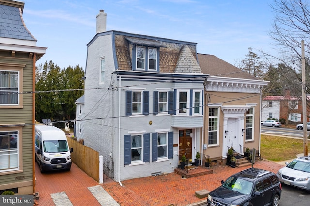 victorian home with brick siding, fence, entry steps, a chimney, and crawl space