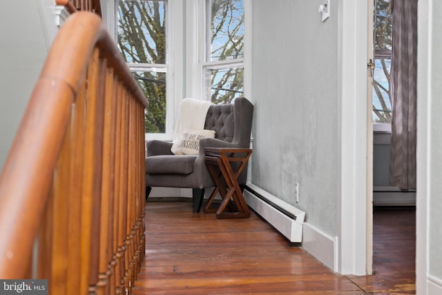 living area featuring a baseboard radiator and wood finished floors