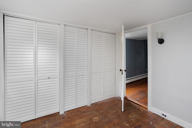 unfurnished bedroom featuring hardwood / wood-style floors, a closet, and a baseboard radiator