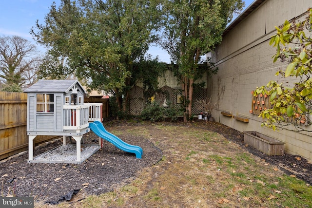 view of yard featuring a fenced backyard and a playground