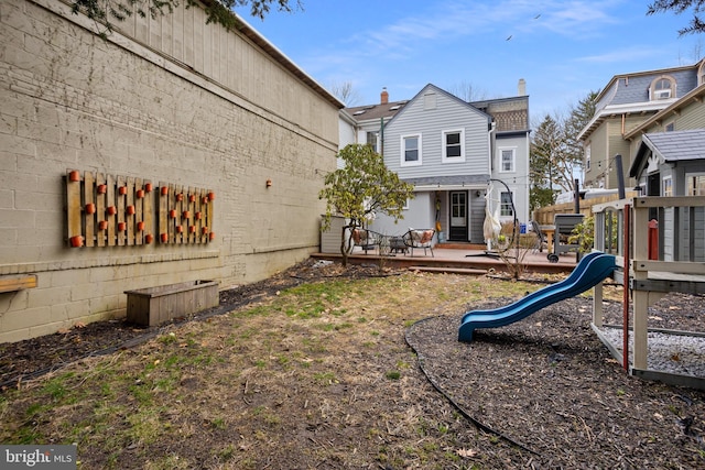 rear view of property featuring a playground