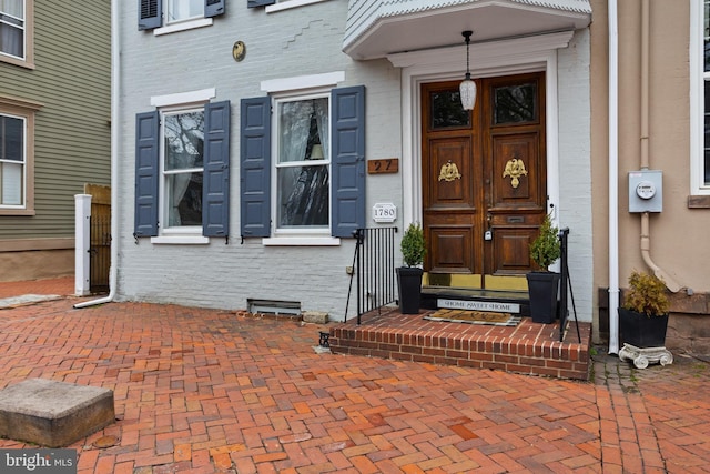 property entrance with brick siding and crawl space