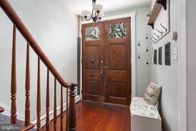 foyer featuring an inviting chandelier, stairway, and dark wood-style flooring