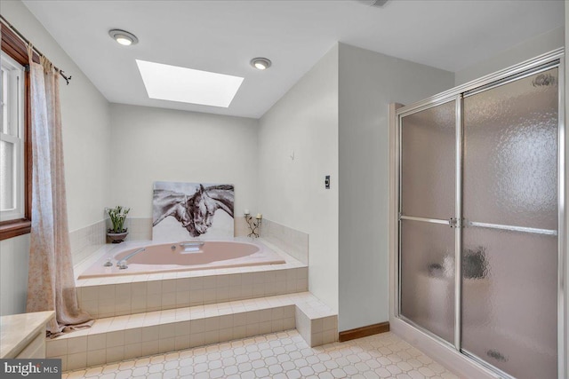 bathroom featuring a skylight, a shower stall, and a bath