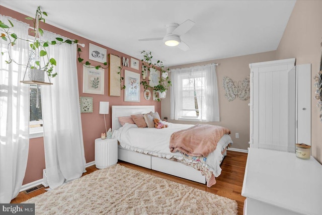 bedroom with visible vents, ceiling fan, baseboards, and wood finished floors