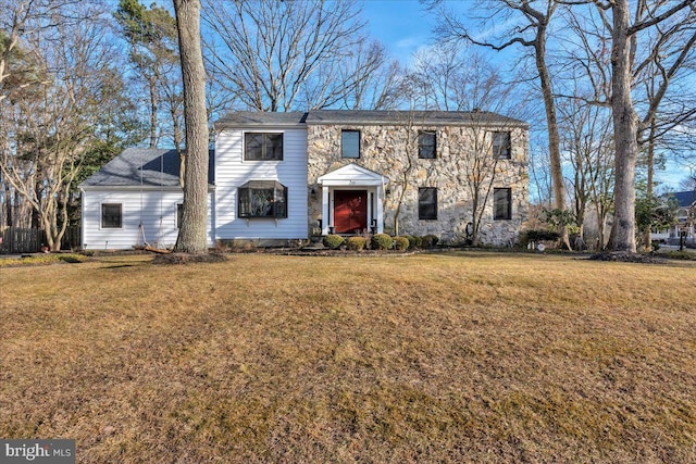 view of front facade featuring stone siding and a front lawn