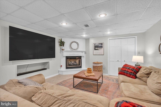 living room featuring carpet, recessed lighting, a fireplace with raised hearth, visible vents, and baseboards