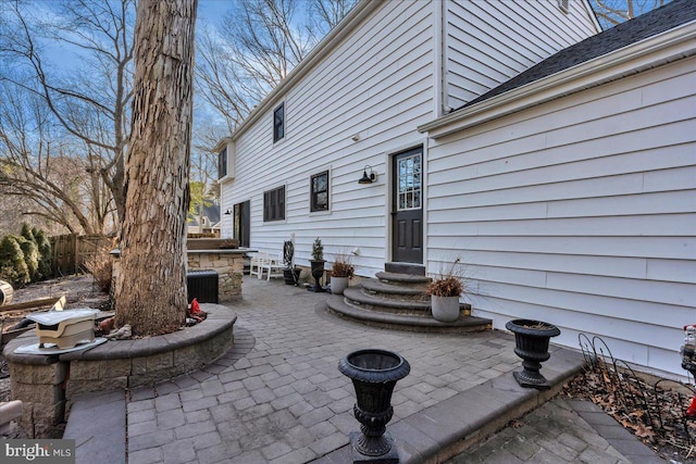 view of patio with entry steps, central air condition unit, and fence