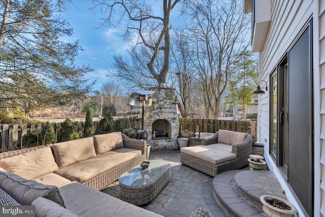 view of patio with an outdoor living space with a fireplace and a fenced backyard