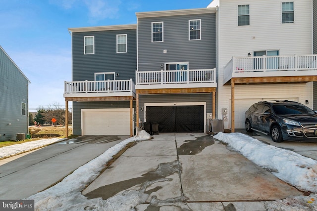 view of front of home featuring central AC, driveway, and an attached garage