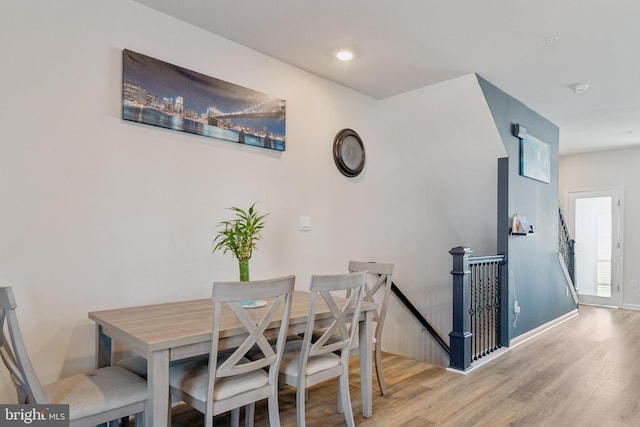 dining area featuring light wood-style flooring and baseboards