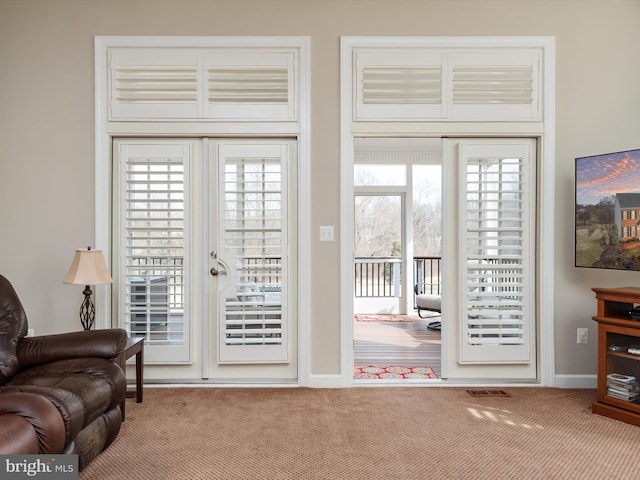 doorway with baseboards and carpet flooring