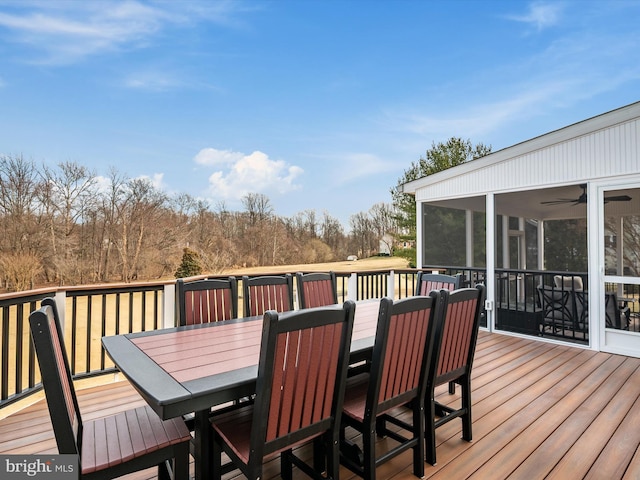 deck with a sunroom and outdoor dining area