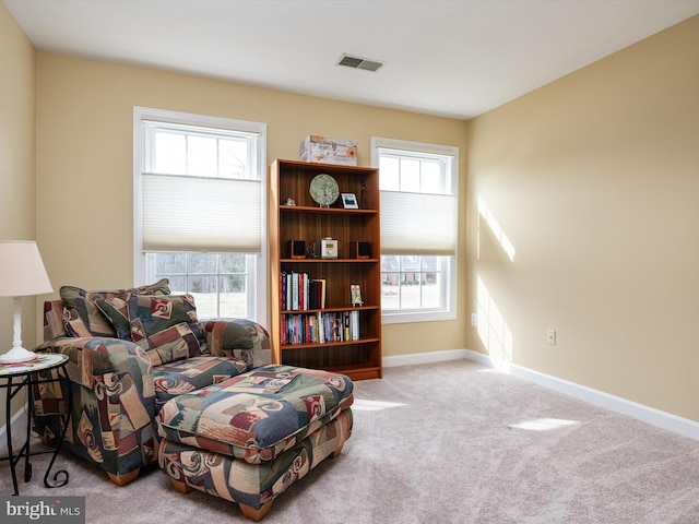 sitting room featuring a wealth of natural light, carpet flooring, visible vents, and baseboards