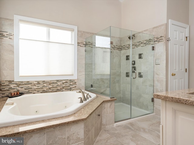 full bathroom featuring a tub with jets, a stall shower, and vanity