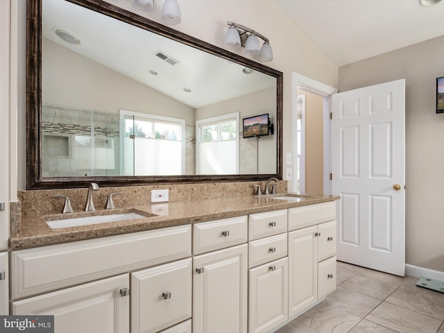 bathroom featuring vaulted ceiling, visible vents, and a sink