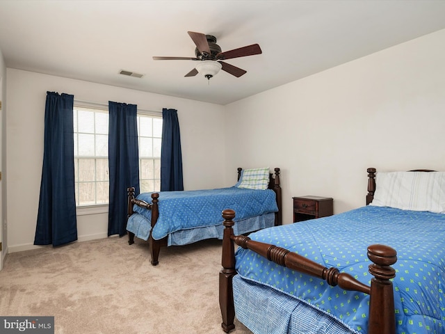 bedroom featuring baseboards, a ceiling fan, visible vents, and light colored carpet