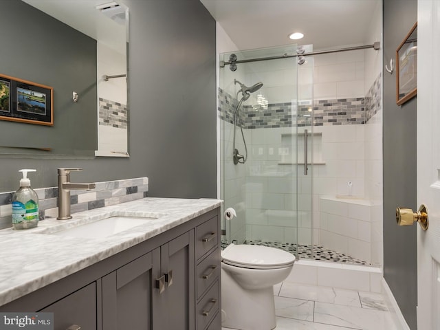 bathroom featuring a stall shower, marble finish floor, vanity, and toilet