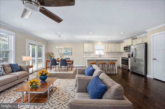 living area featuring crown molding, recessed lighting, dark wood-type flooring, ceiling fan, and baseboards