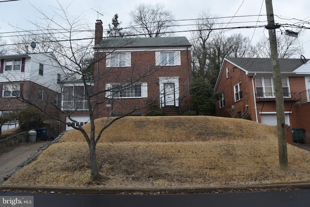 view of front of house with a chimney and brick siding