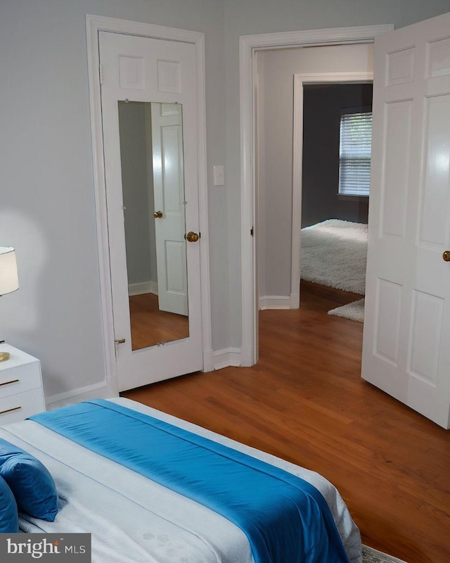 bedroom featuring wood finished floors and baseboards