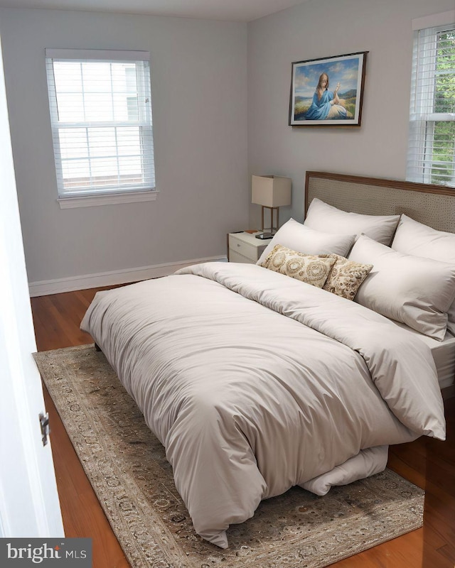 bedroom with baseboards and wood finished floors