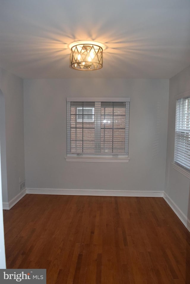 unfurnished room with wood finished floors and baseboards