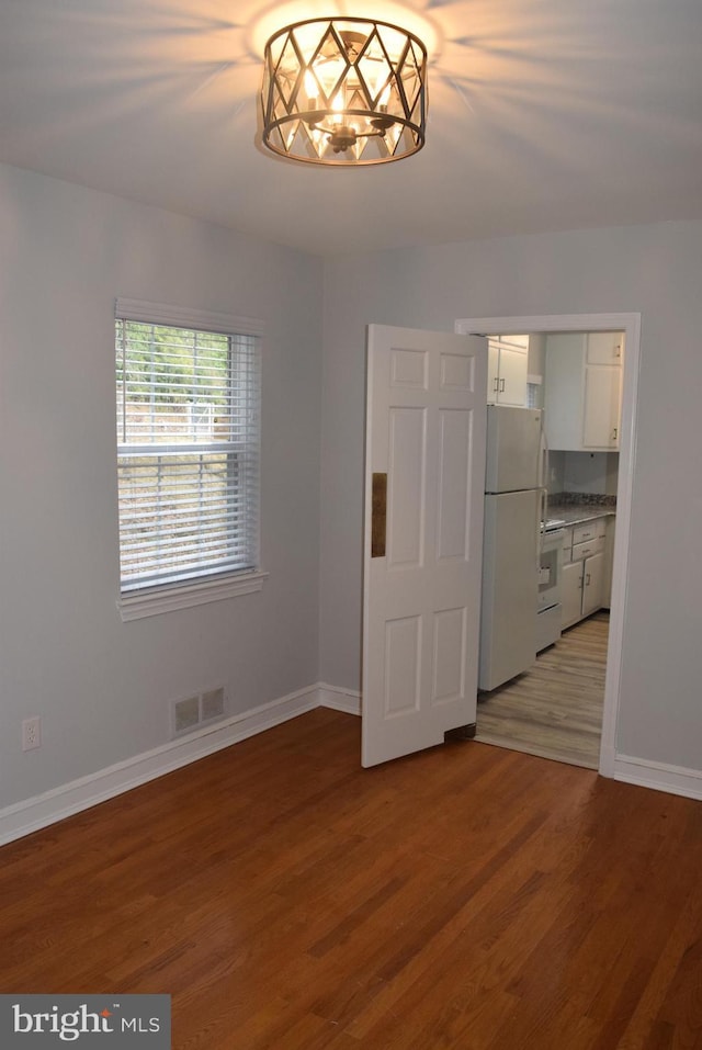 interior space featuring baseboards, visible vents, and wood finished floors