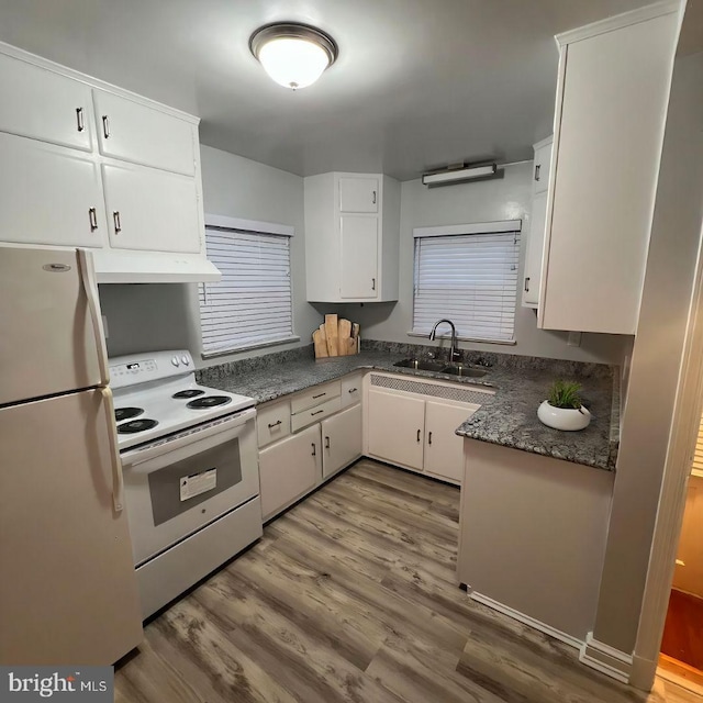 kitchen with under cabinet range hood, white appliances, a sink, white cabinets, and dark countertops