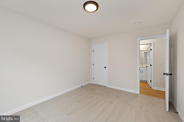 unfurnished bedroom with light carpet and baseboards