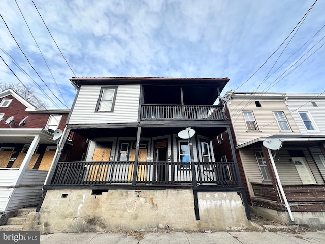 multi unit property with a porch and a balcony