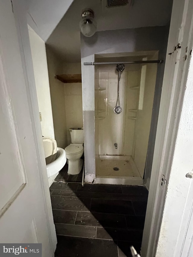 full bath with tile patterned flooring, a shower stall, and toilet