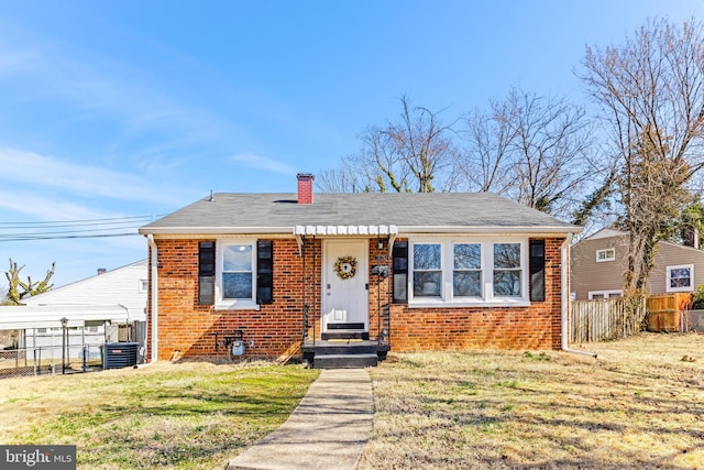 bungalow-style home with a chimney, a front yard, fence, and brick siding