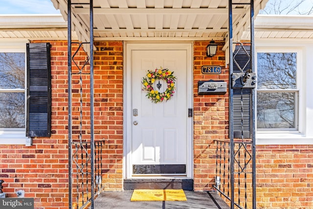 doorway to property featuring brick siding