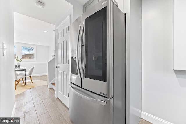 kitchen with recessed lighting, baseboards, white cabinetry, and stainless steel fridge with ice dispenser