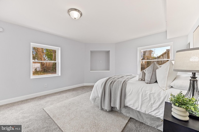 carpeted bedroom with multiple windows and baseboards