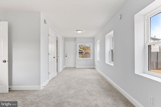 hallway featuring carpet flooring, visible vents, and baseboards