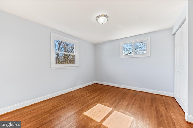 unfurnished bedroom featuring baseboards, a closet, and wood finished floors