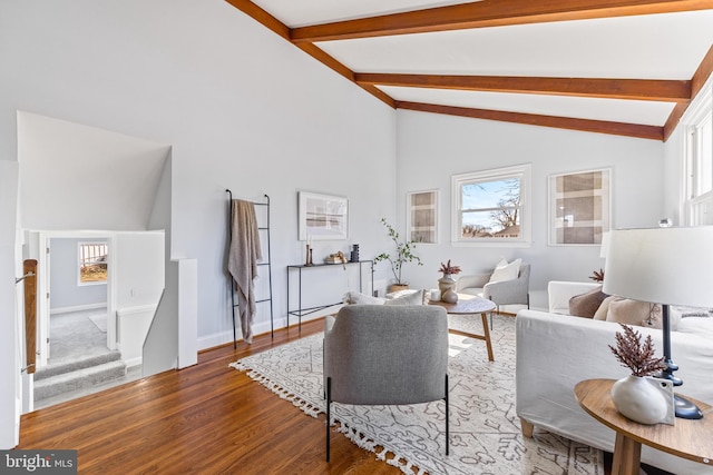 living area featuring baseboards, stairway, wood finished floors, high vaulted ceiling, and beam ceiling