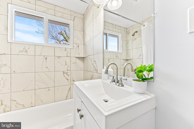 bathroom with shower / tub combo, tile walls, and vanity