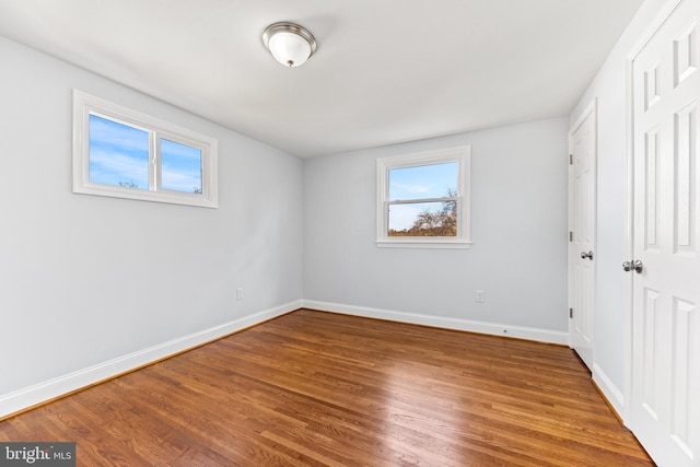 unfurnished bedroom featuring a closet, baseboards, and wood finished floors