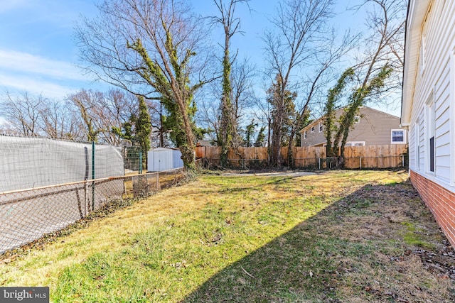 view of yard with an outbuilding, a fenced backyard, and a storage shed