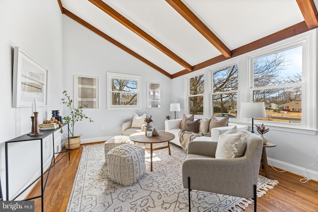 living area with high vaulted ceiling, wood finished floors, beam ceiling, and baseboards