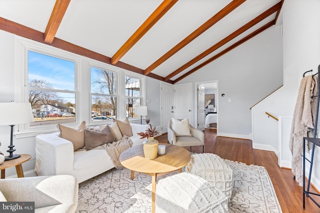 living room featuring high vaulted ceiling, beam ceiling, baseboards, and wood finished floors