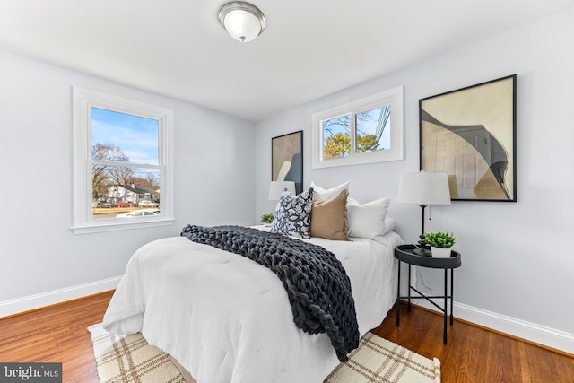 bedroom with baseboards and wood finished floors