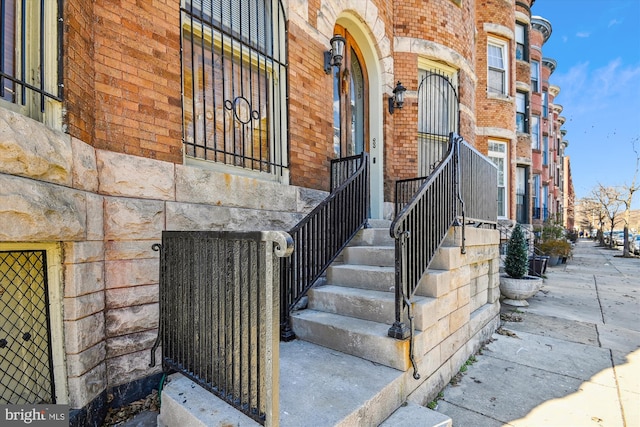 doorway to property featuring brick siding